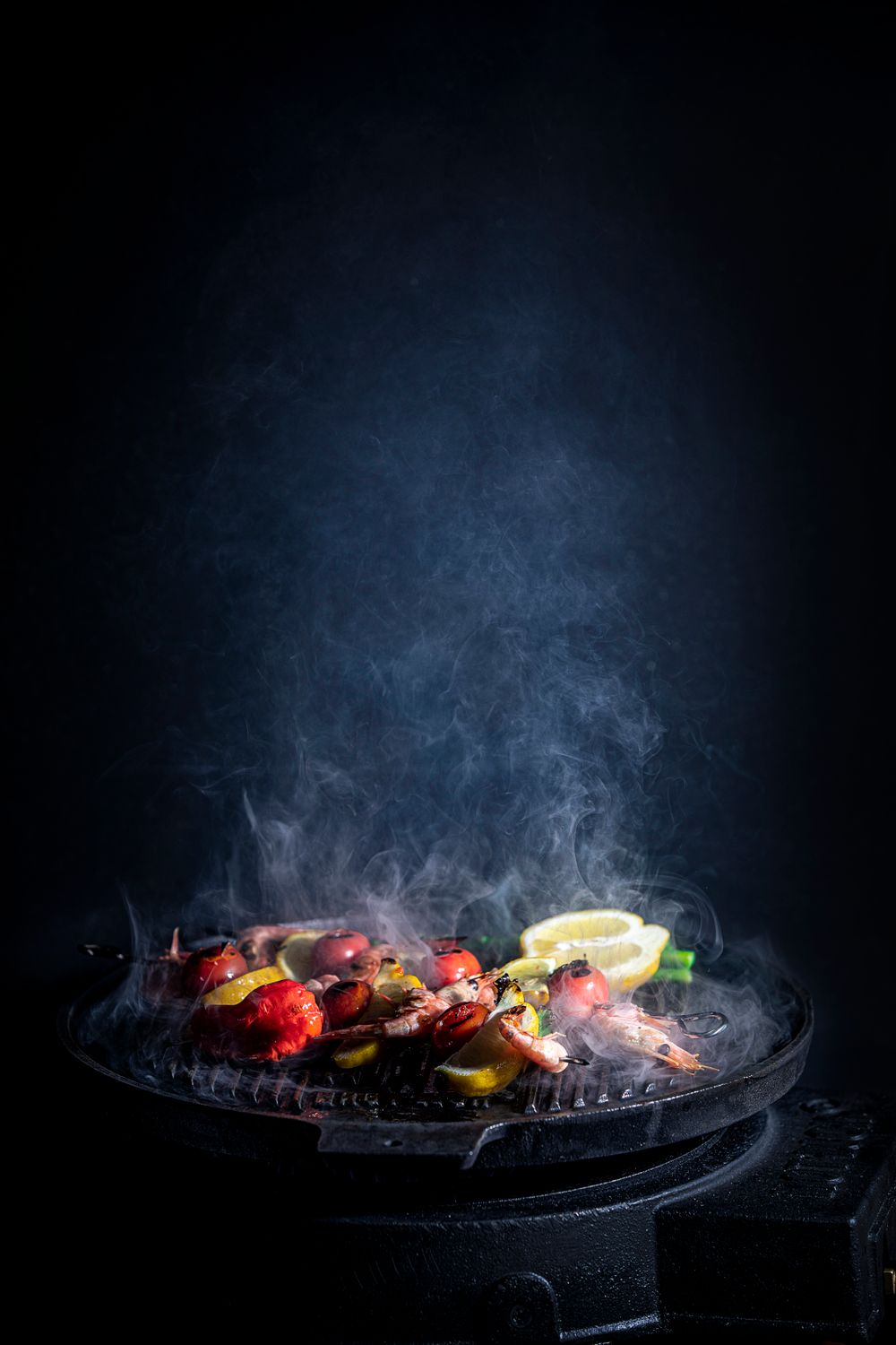 Vegetables and lemon grilling under blue smoke